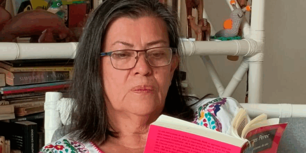 Aura Encinales Ardila, mujer mayor de 55 años, sentada leyendo un libro .