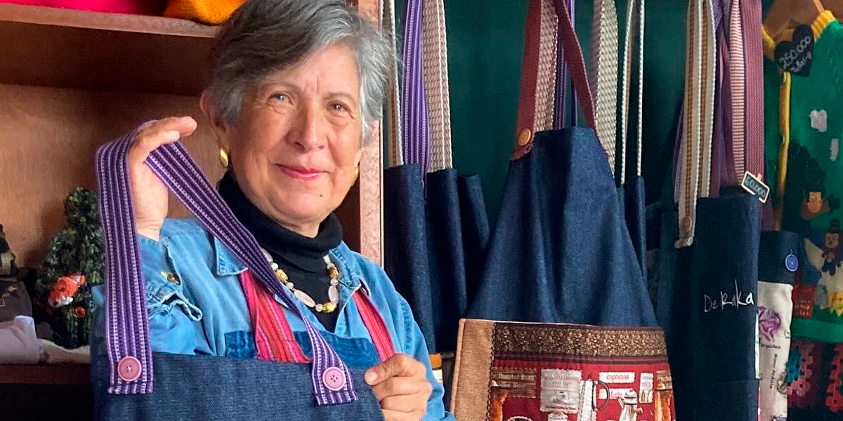 Yineth Bedoya, emprendedora senior. Yineth Bedoya, emprendedora senior, en su tienda exhibiendo un delantal azul.