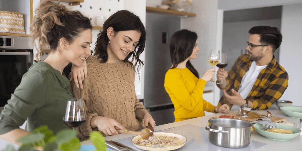 Grupo de amigos cocinando y conversando Grupo de amigos cocinando y conversando
