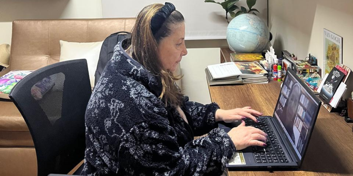 Laura Polo, profesora de ingl&eacute;s, sentada en el estudio de su casa trabajando en el port&aacute;til