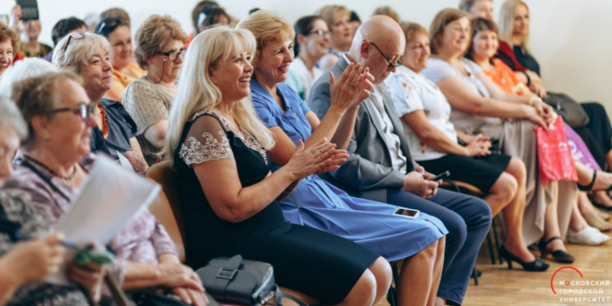 Auditorio de la Silver University en Mosc&uacute;, Rusia, con decenas de personas mayores sentadas aplaudiendo con entusiasmo.