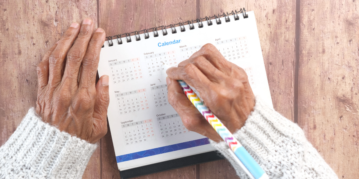 Mano adulta marcando una fecha en un calendario.